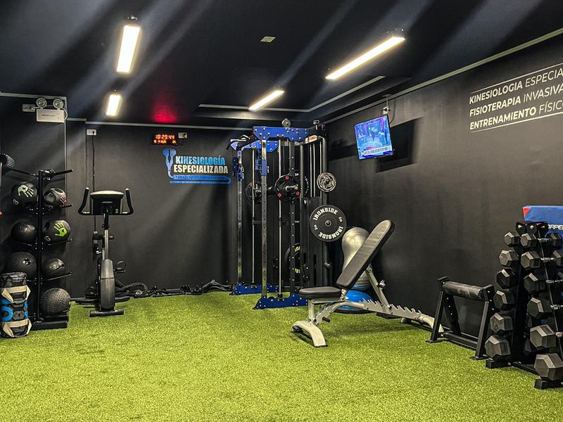 Sala de entrenamiento con rack, bancos y mancuernas